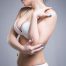 Woman in white push up bra on gray background perfect female breast studio shot